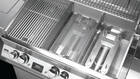 Aufbau eines Grills (v.r.n.l.): H-Brenner, Flammenabweiser, Rost
